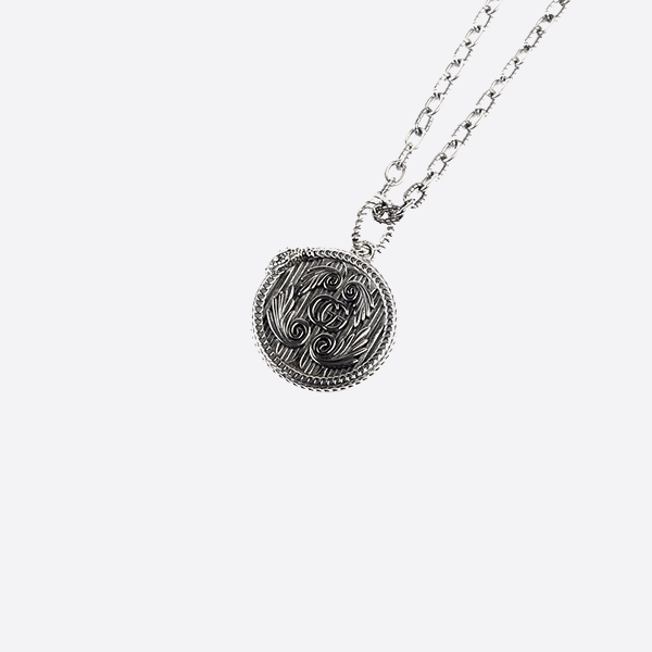 A delicate snake ring engraved with the Gucci Snake Edge, and a round pendant necklace adorned with a double G wing.